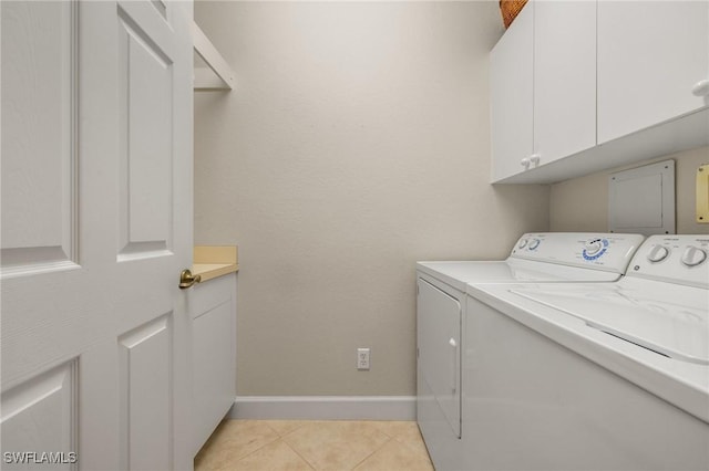 laundry room with cabinets, washing machine and dryer, and light tile patterned floors