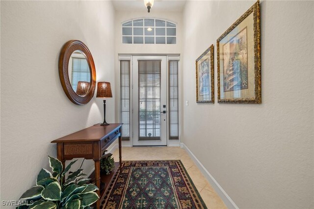 tiled foyer featuring a towering ceiling