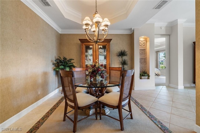 tiled dining area with a tray ceiling, crown molding, and an inviting chandelier