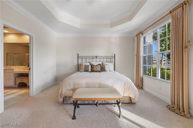 bedroom with a raised ceiling, ensuite bath, light colored carpet, and ornamental molding