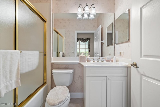 full bathroom featuring vanity, toilet, and bath / shower combo with glass door