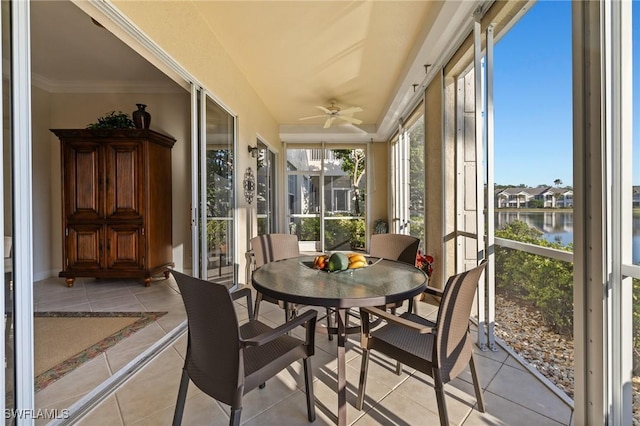 sunroom featuring ceiling fan and a water view