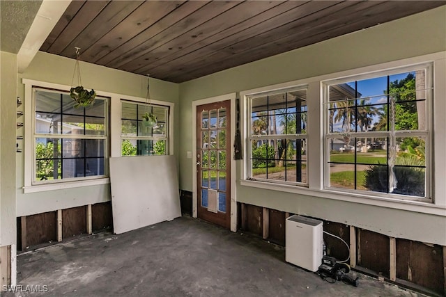 unfurnished sunroom with a healthy amount of sunlight and wood ceiling