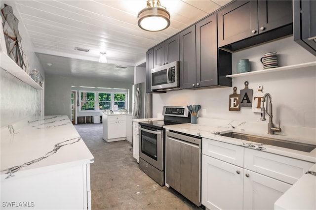 kitchen featuring white cabinetry, sink, stainless steel appliances, and light stone counters