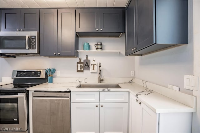 kitchen with sink, white cabinets, and stainless steel appliances