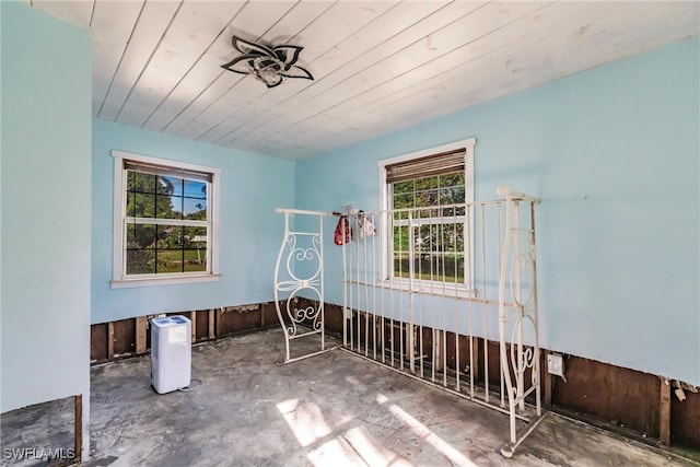 unfurnished room featuring wood ceiling and a wealth of natural light