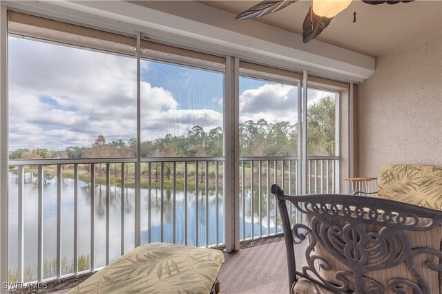 sunroom featuring a water view