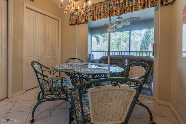 tiled dining space featuring ceiling fan with notable chandelier