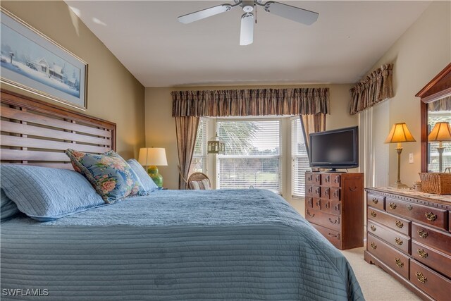 carpeted bedroom with multiple windows, lofted ceiling, and ceiling fan