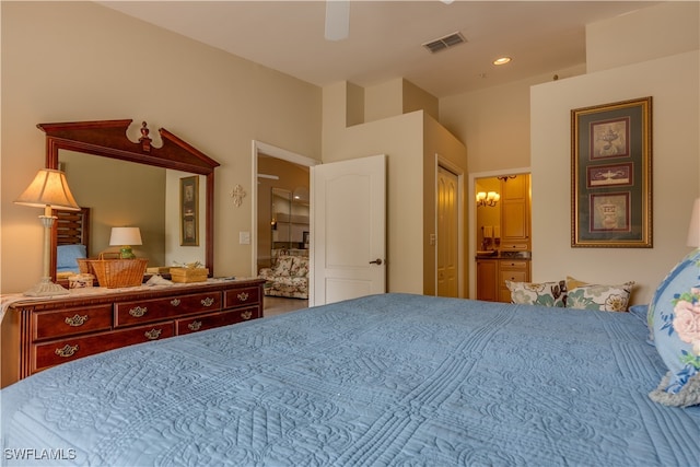 bedroom featuring ceiling fan with notable chandelier, a closet, and connected bathroom