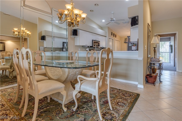 tiled dining space with ceiling fan with notable chandelier and lofted ceiling