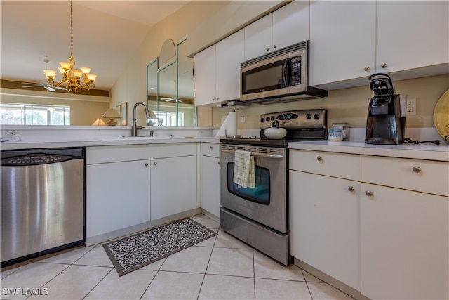 kitchen featuring stainless steel appliances, pendant lighting, light tile patterned floors, white cabinetry, and lofted ceiling