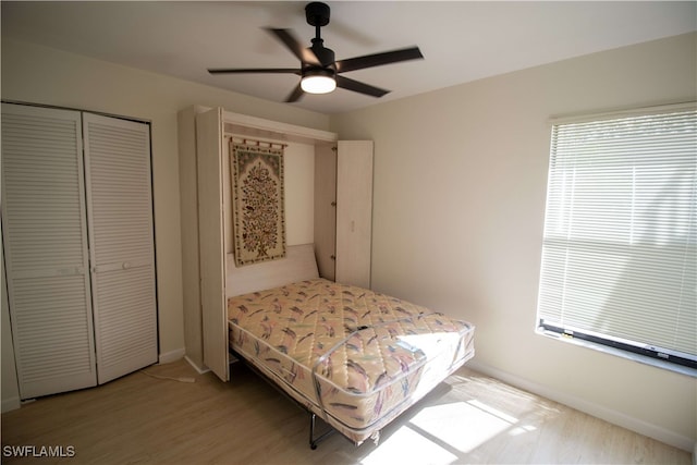 bedroom featuring ceiling fan, a closet, and light wood-type flooring