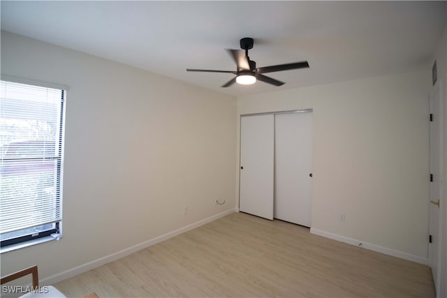 unfurnished bedroom featuring a closet, light hardwood / wood-style floors, and ceiling fan