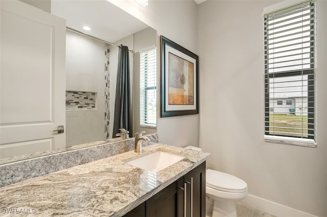 bathroom featuring a shower with curtain, a wealth of natural light, vanity, and toilet