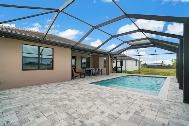 view of pool with a patio, glass enclosure, and ceiling fan