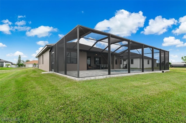 rear view of house with a lawn, glass enclosure, and a patio area