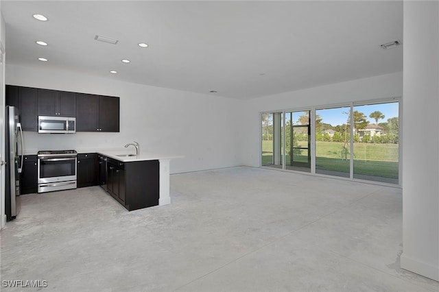 kitchen with kitchen peninsula, appliances with stainless steel finishes, and sink