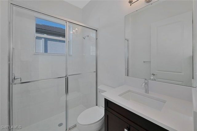 bathroom featuring vanity, toilet, and a shower with door