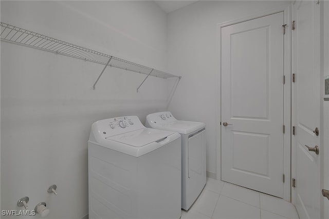 washroom with light tile patterned floors and washing machine and clothes dryer