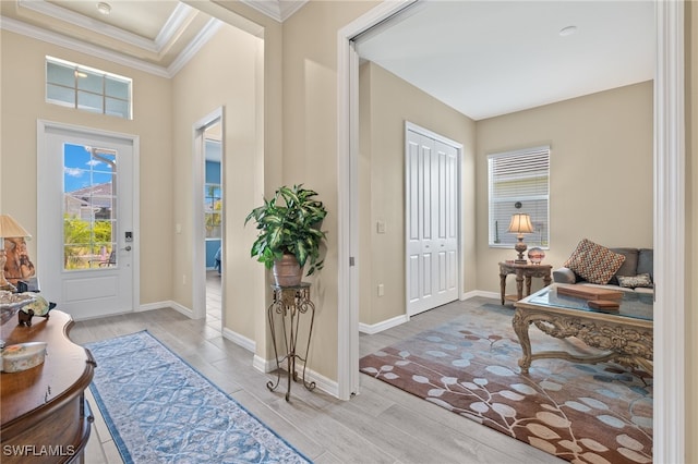 foyer with crown molding and light hardwood / wood-style floors