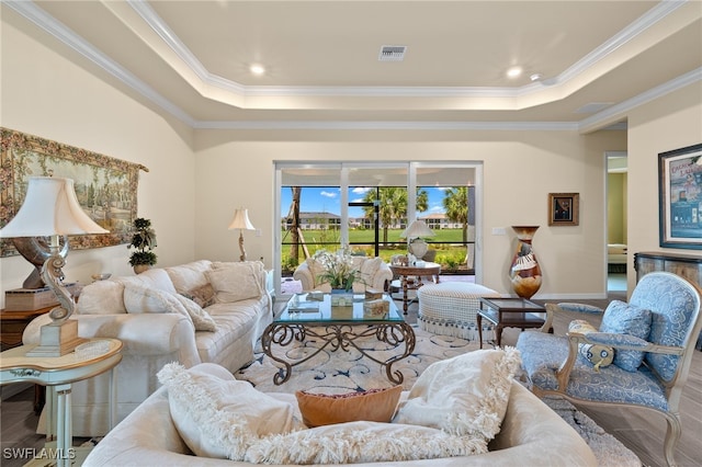 living room with wood-type flooring, a raised ceiling, and crown molding