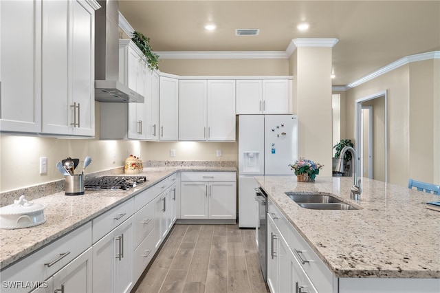 kitchen featuring ornamental molding, white cabinetry, wall chimney exhaust hood, and sink