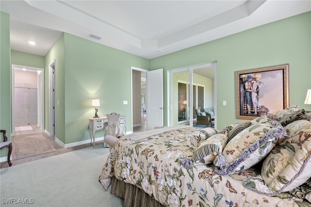 bedroom featuring connected bathroom and light colored carpet