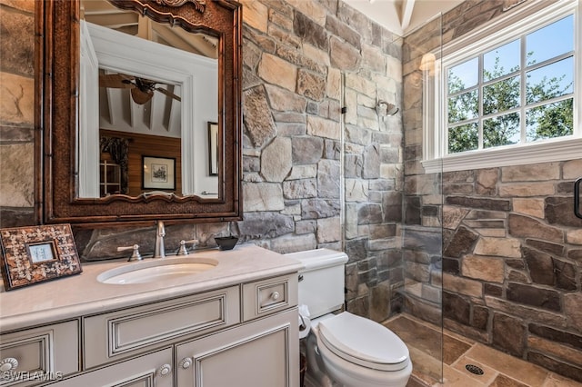 bathroom featuring a shower, vanity, and toilet