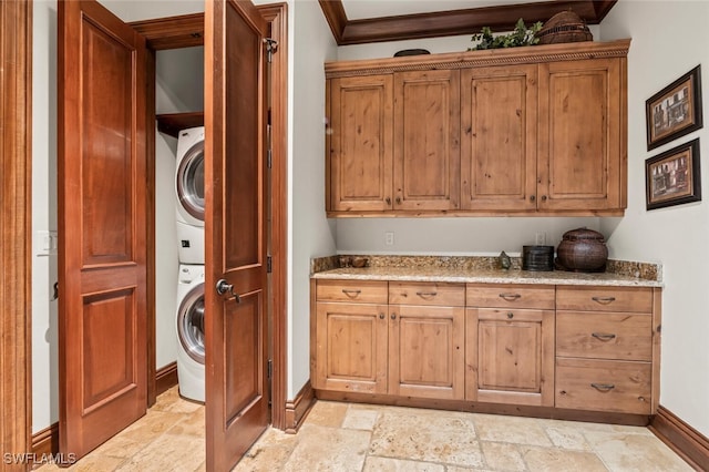 laundry room with stacked washer and dryer and cabinets