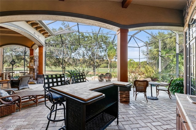 view of patio / terrace with glass enclosure and an outdoor bar