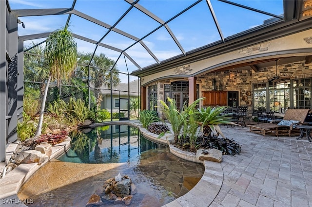 view of pool with a patio, glass enclosure, and ceiling fan