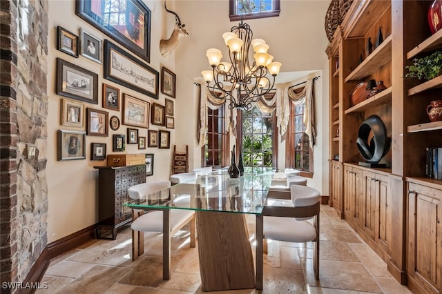 dining space featuring built in shelves, a chandelier, and a high ceiling