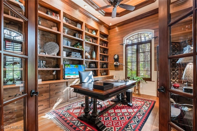 office with wood walls, light hardwood / wood-style flooring, ceiling fan, and ornamental molding