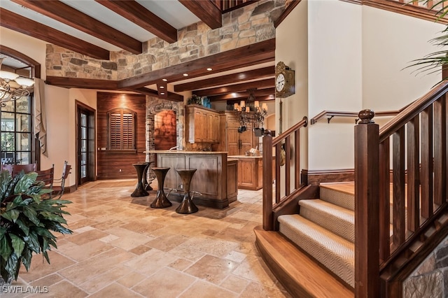 bar with beam ceiling and a chandelier