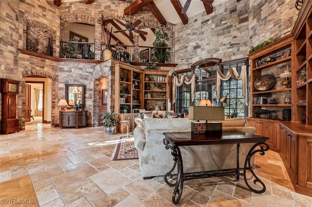 living area with beamed ceiling, ceiling fan, and high vaulted ceiling