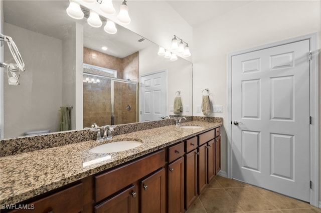 bathroom featuring a shower with door, vanity, and tile patterned flooring