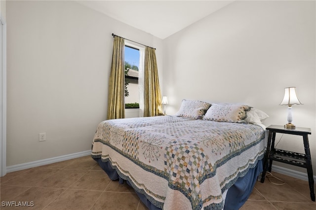 bedroom with tile patterned floors and vaulted ceiling