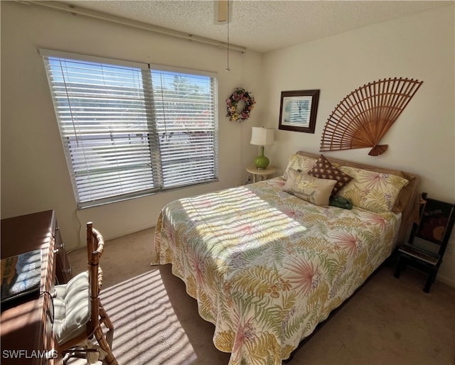 carpeted bedroom featuring a textured ceiling and ceiling fan