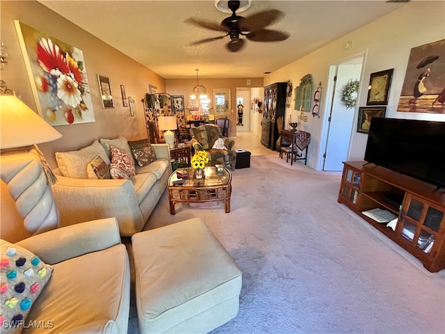 carpeted living room with ceiling fan with notable chandelier