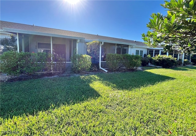 view of front of property with a sunroom and a front lawn