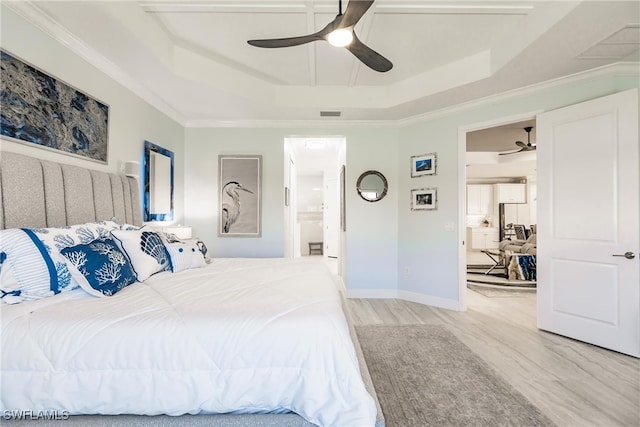 bedroom featuring ornamental molding, a raised ceiling, ceiling fan, connected bathroom, and light hardwood / wood-style floors