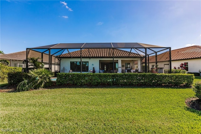 back of house with a lanai and a yard