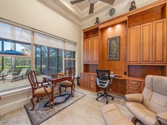 office area featuring ceiling fan, light hardwood / wood-style floors, built in desk, and crown molding