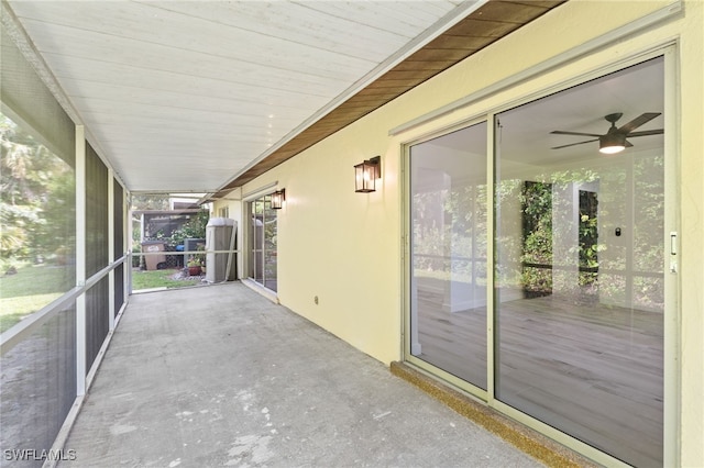 unfurnished sunroom featuring wooden ceiling, ceiling fan, and a healthy amount of sunlight