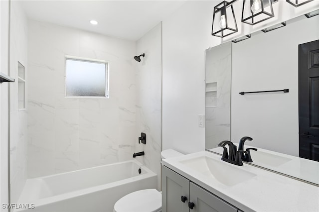 full bathroom featuring vanity, tiled shower / bath combo, and toilet