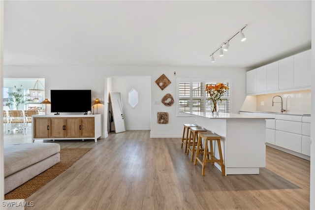 kitchen featuring white cabinets, light hardwood / wood-style floors, and a kitchen island