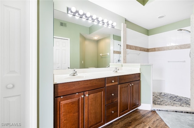 bathroom featuring a sink, wood finished floors, visible vents, a closet, and walk in shower