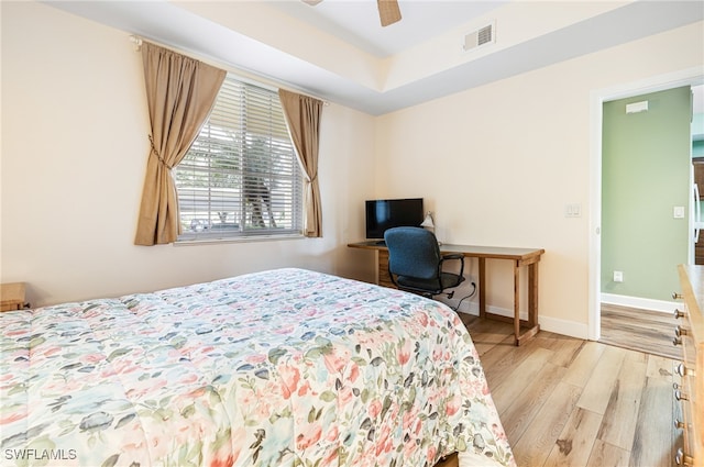 bedroom with baseboards, a ceiling fan, visible vents, and light wood-style floors