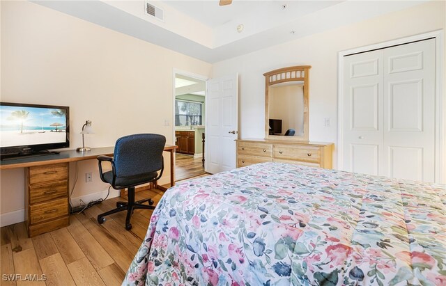 bedroom with light wood finished floors, visible vents, baseboards, a ceiling fan, and a closet